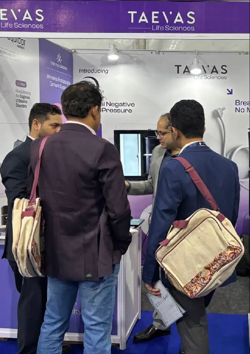 Visitors watching a device demonstration on screen at the Taevas Life Sciences stall
