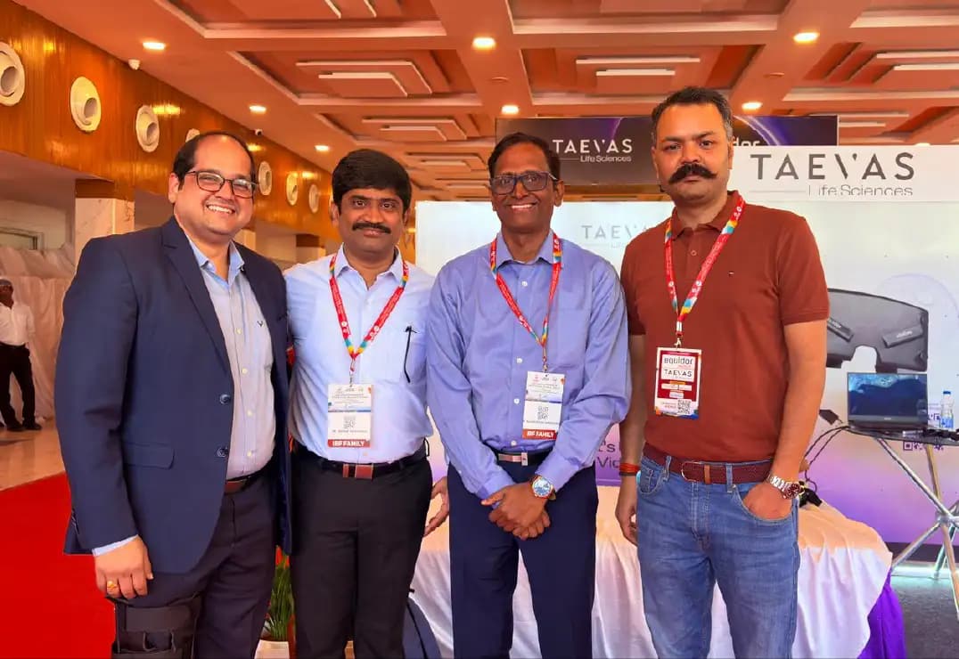Four delegates wearing conference badges in front of the Taevas Life Sciences banner